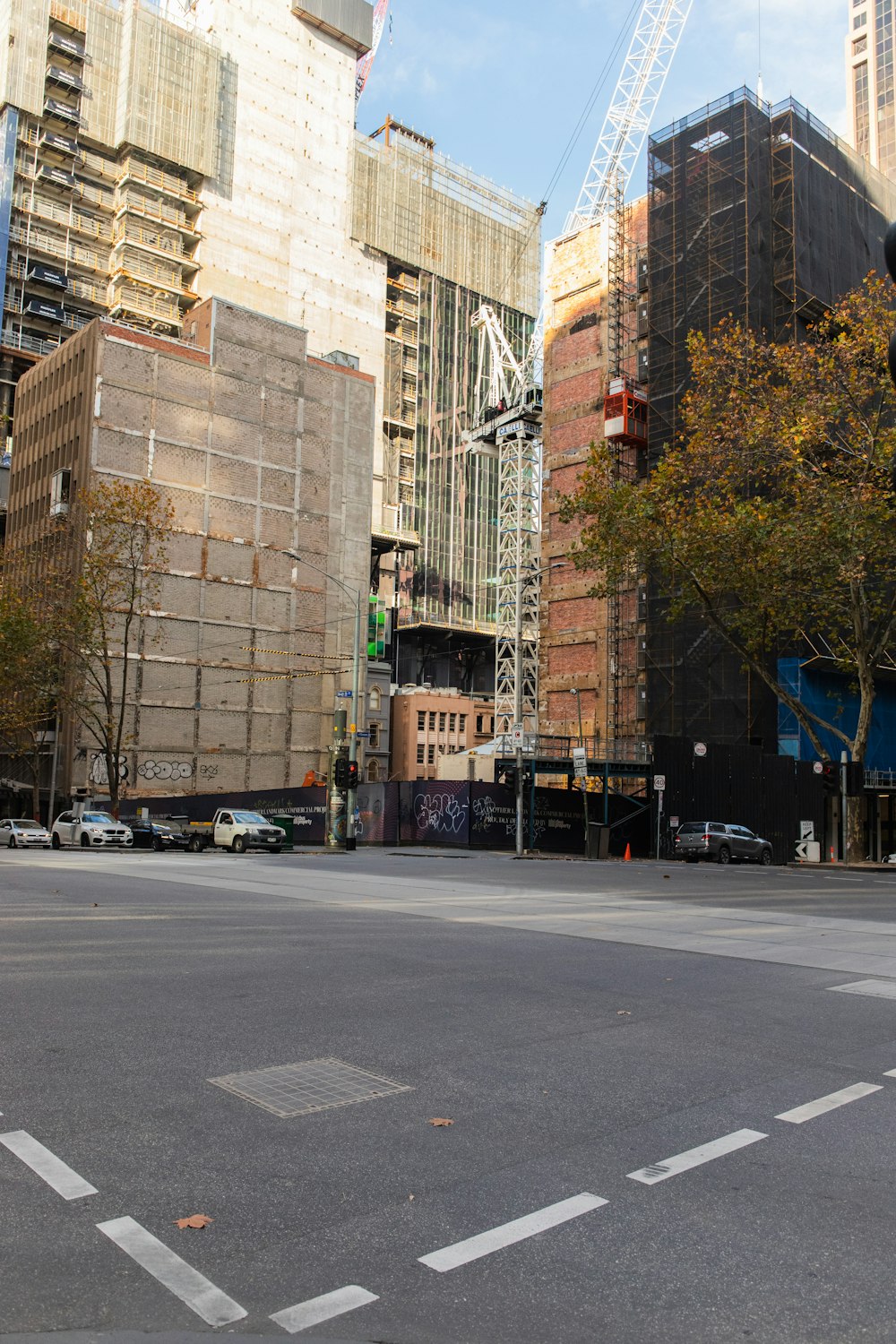 cars parked on side of the road near brown concrete building during daytime