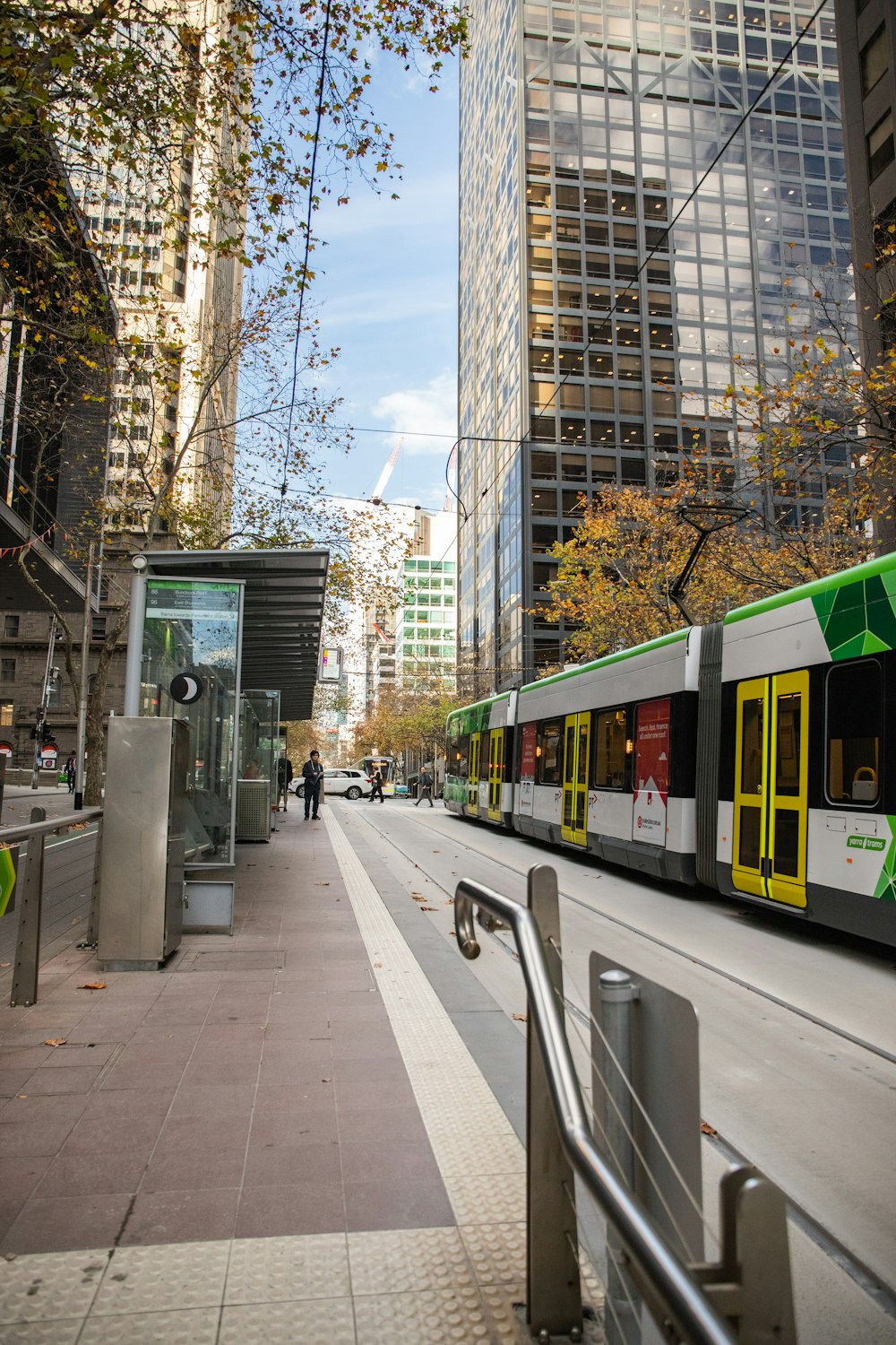 green and yellow train on gray concrete road during daytime