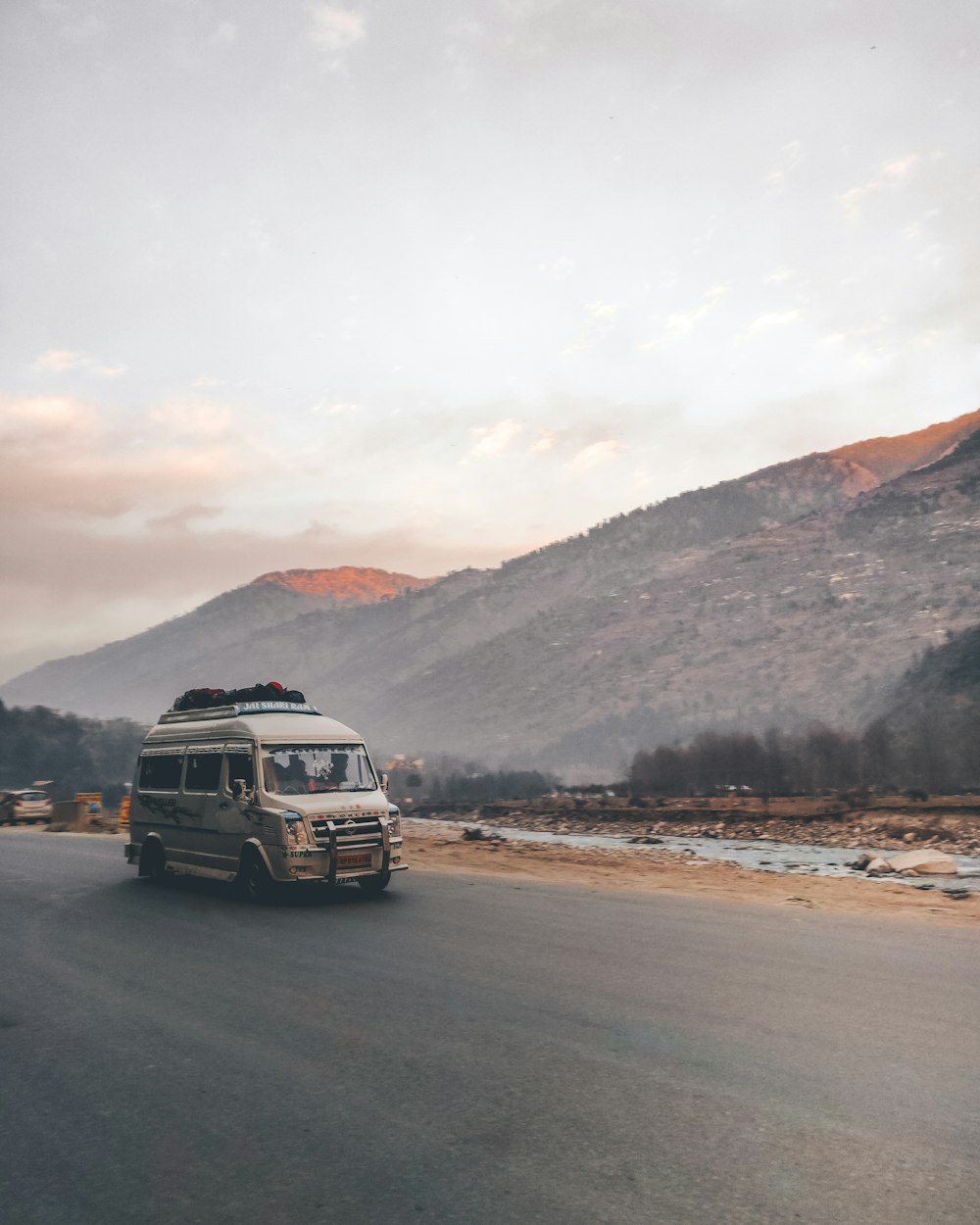 white and black van on road near brown mountain during daytime