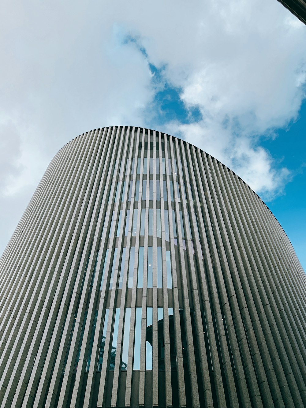 gray concrete building under blue sky and white clouds during daytime