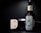 A bottle of beard oil with a silver dropper cap is displayed prominently. The label features an illustration of a bearded man and branding details. Beside it, a metallic clipper head is partially visible against a dark background.
