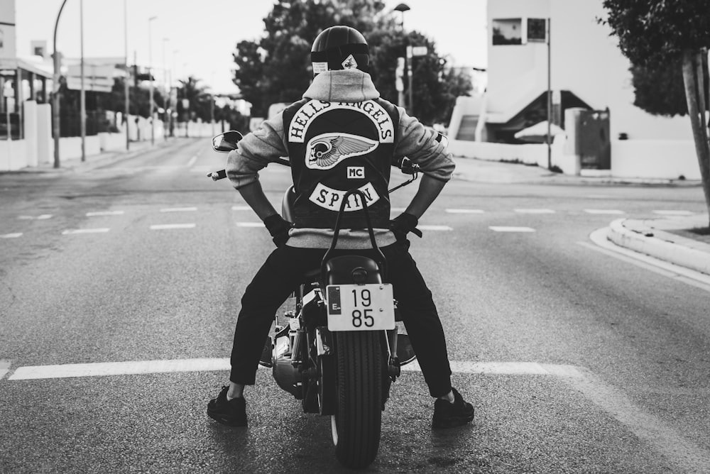 Foto en escala de grises de un hombre montando una motocicleta