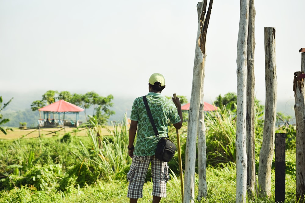 man in green t-shirt and blue and white plaid pants wearing white helmet standing on on on on on