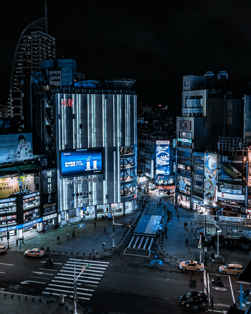 cars on road near high rise buildings during night time