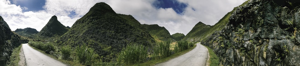 green grass field near mountain under blue sky during daytime