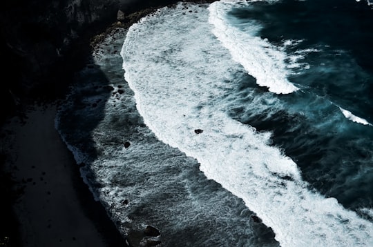 aerial view of ocean waves crashing on shore during daytime in Nusa Penida Indonesia