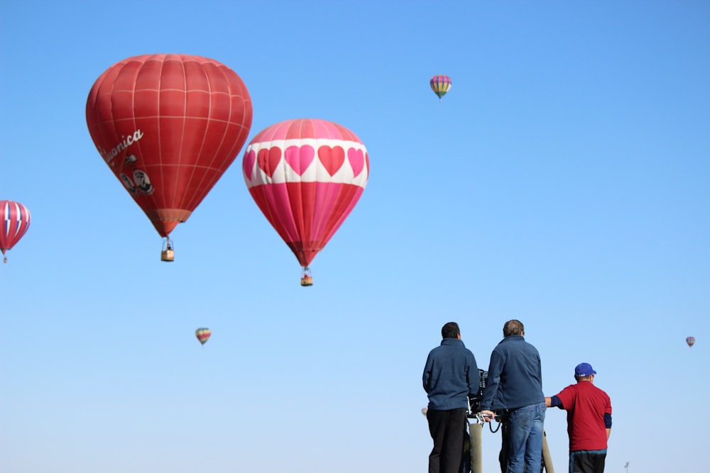 2 men standing near hot air balloons