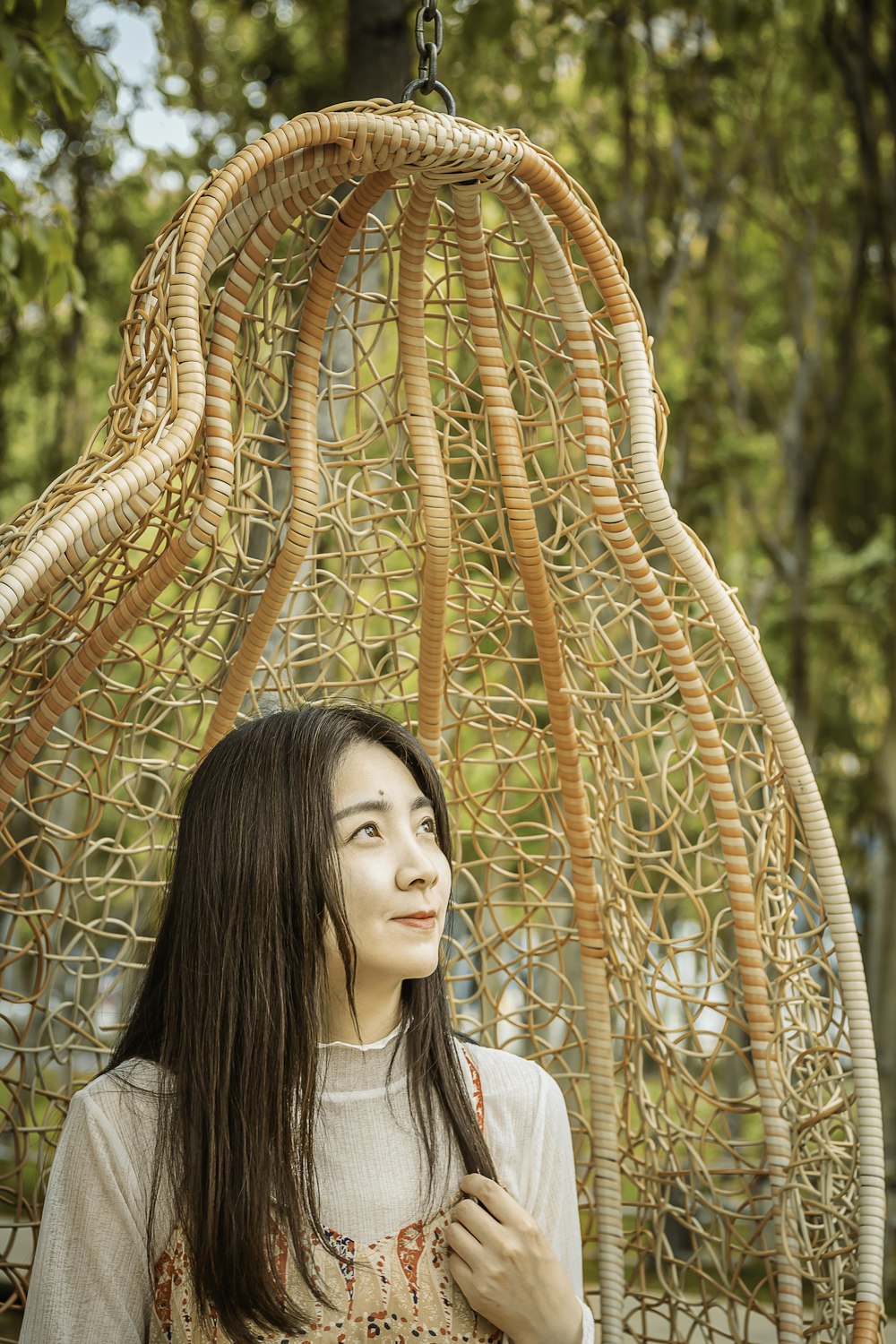 woman in white shirt standing near brown metal fence during daytime