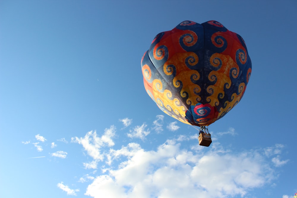 red yellow and blue hot air balloon flying in the sky