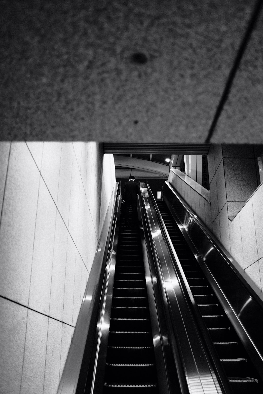 grayscale photo of escalator in building