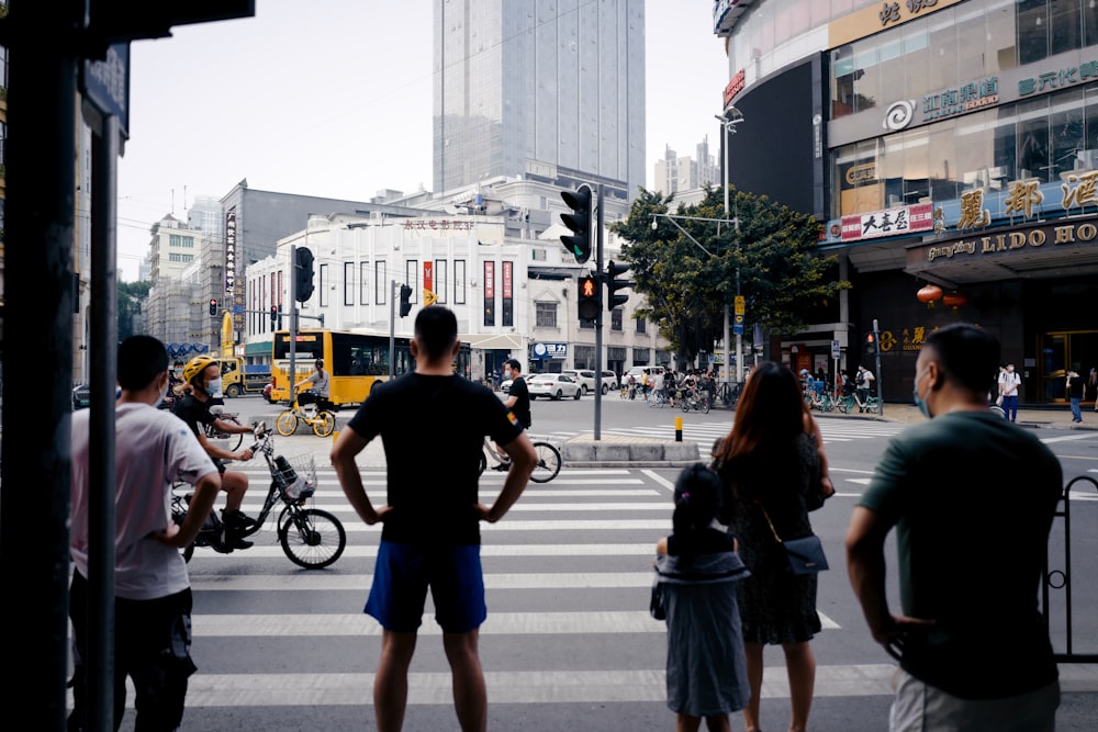 man in black t-shirt and blue shorts standing on pedestrian lane during daytime