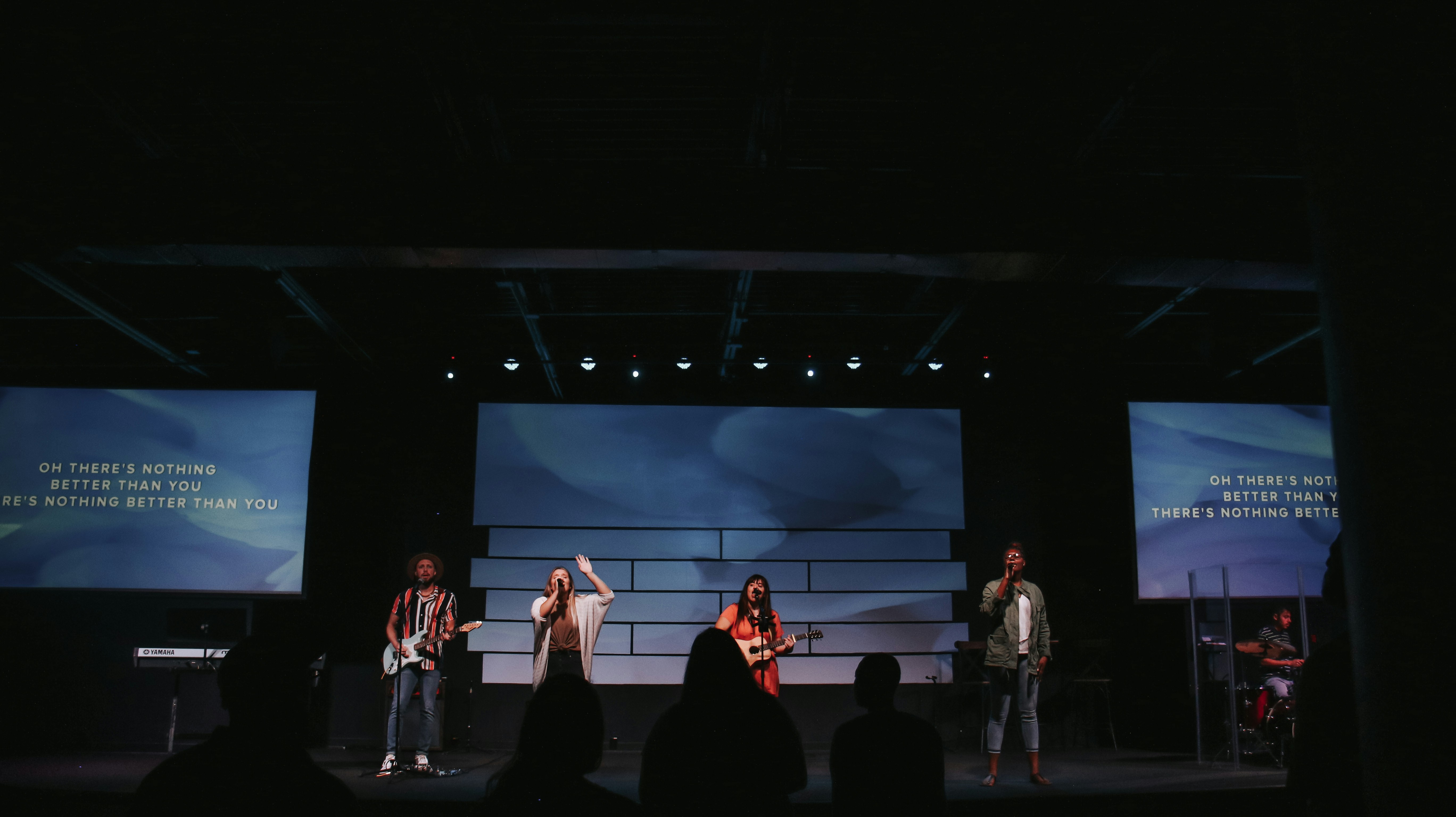 Man in black suit singing on stage