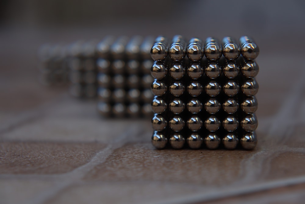 silver and black beads on brown wooden table