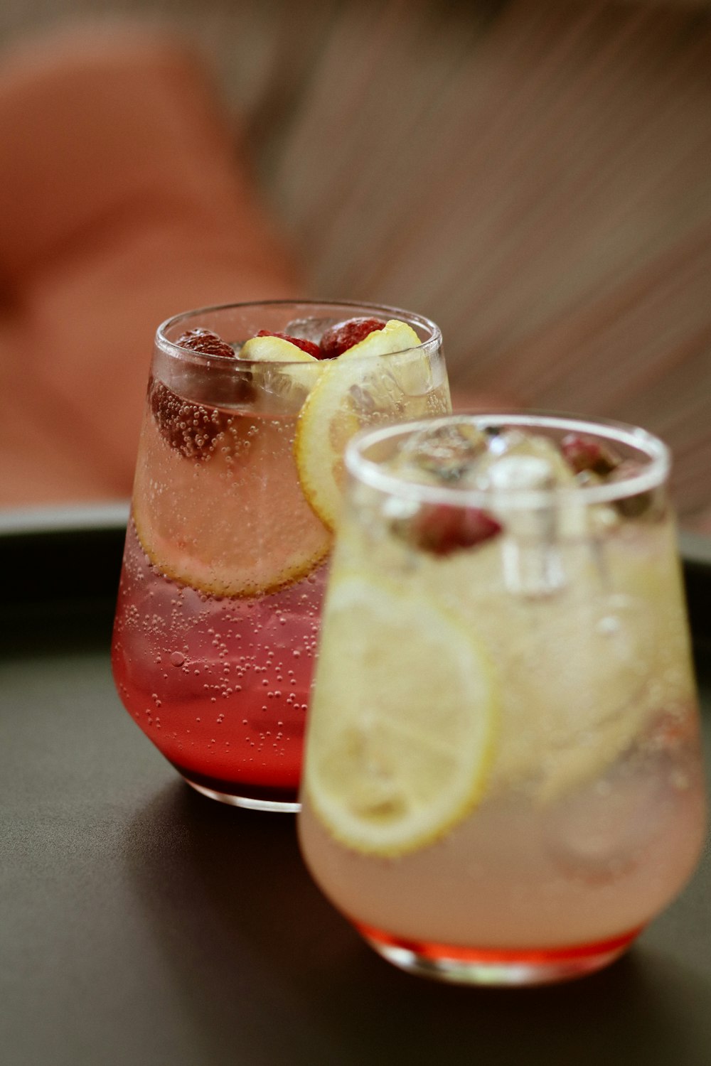 clear drinking glass with red liquid and sliced lemon