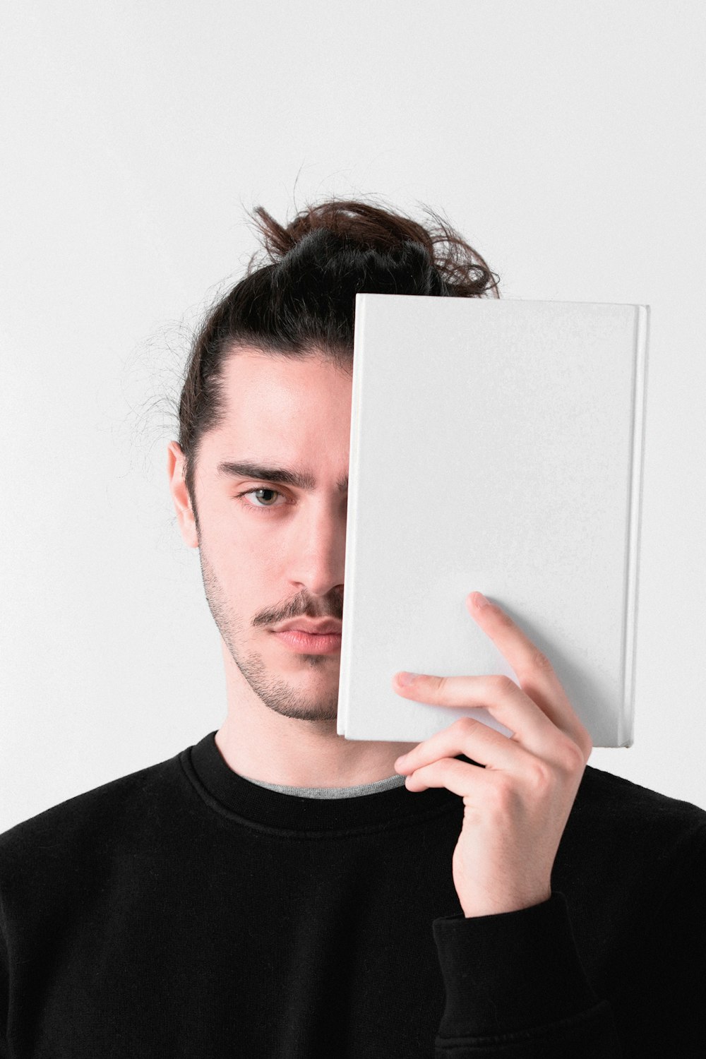 man in black crew neck shirt holding white paper