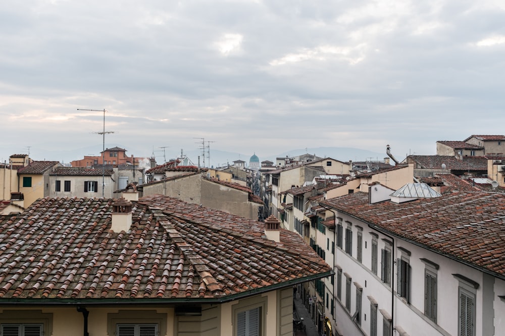 white and brown concrete houses under white clouds during daytime