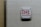A white wall-mounted device displays a message written in red lettering, expressing a strong sentiment against law enforcement.