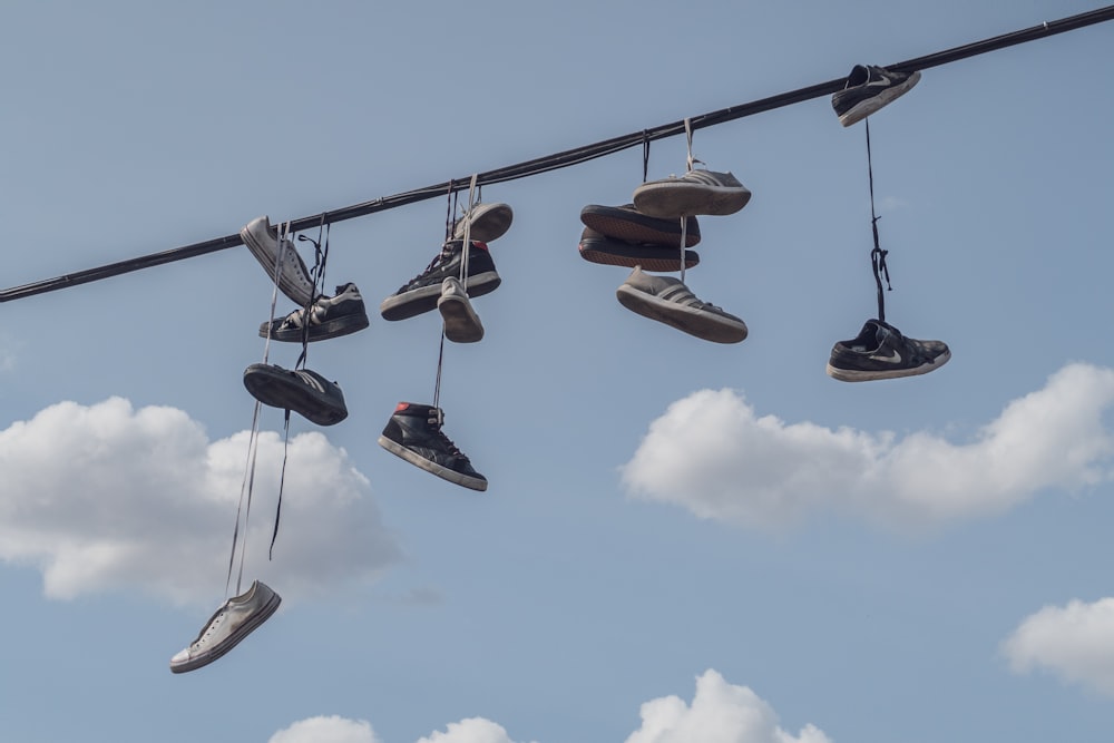 brown and black leather boots hanging on rope under blue sky during daytime