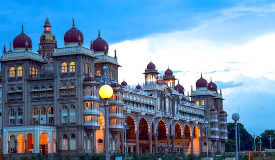 brown and white concrete building under blue sky during daytime in Mysore Palace India