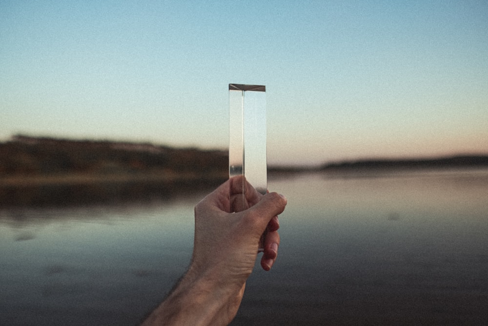 person holding white square frame