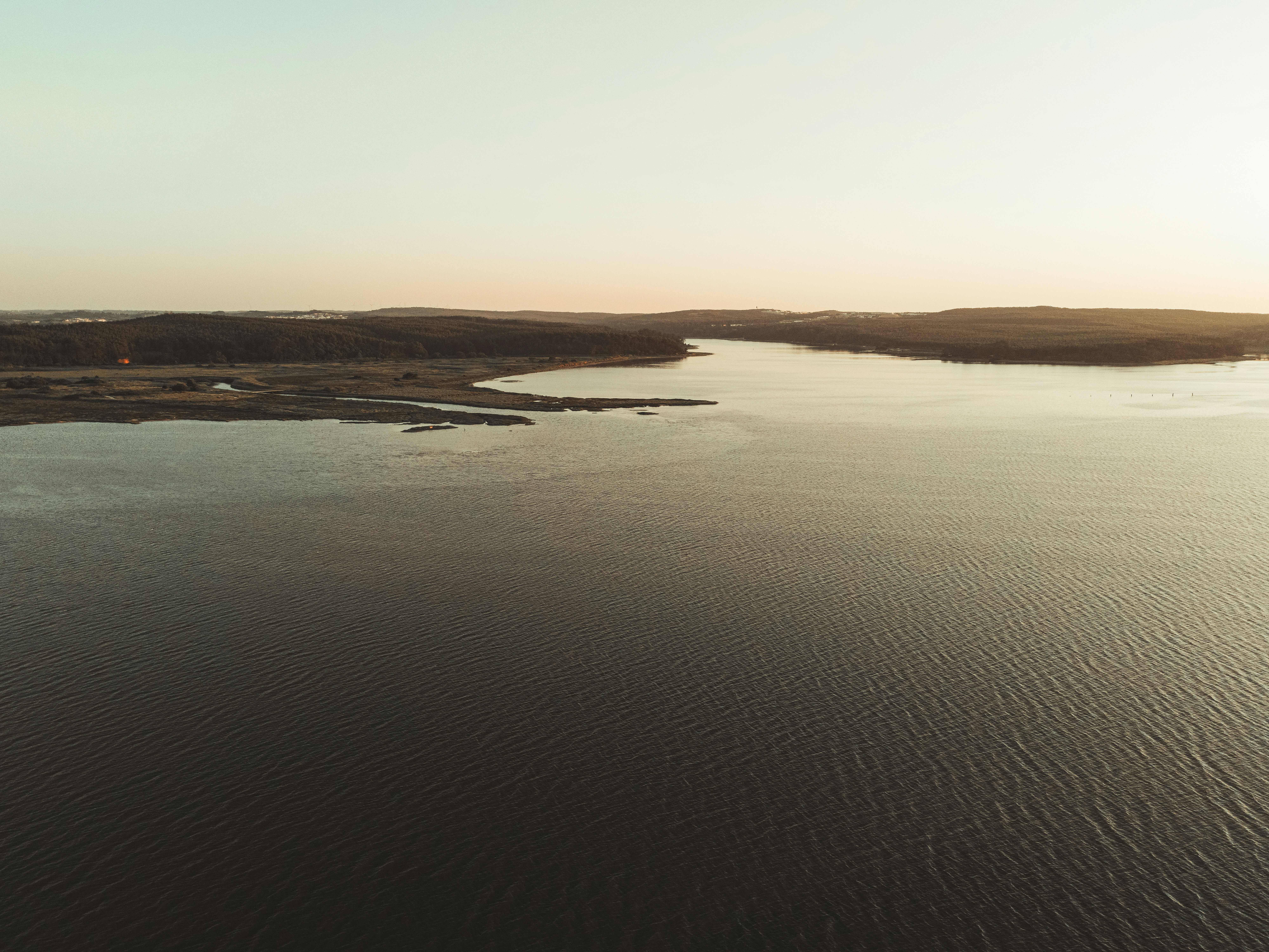 brown sand and body of water during daytime