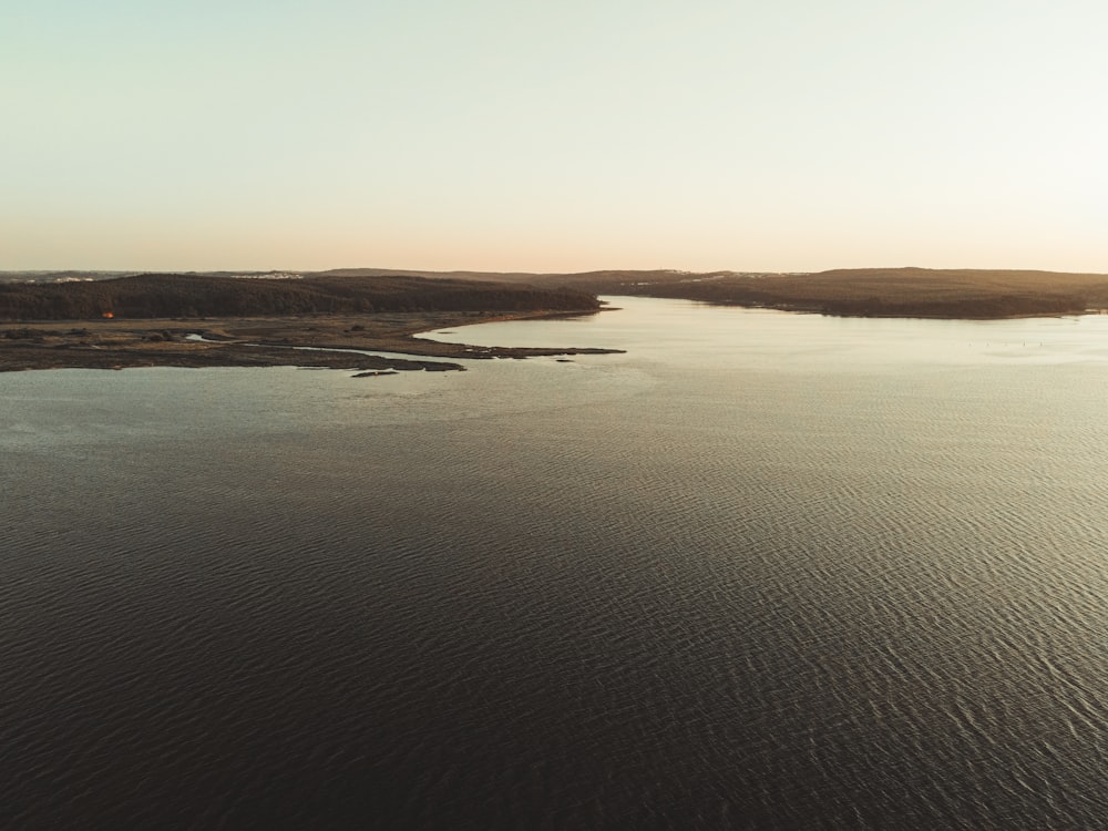 brown sand and body of water during daytime