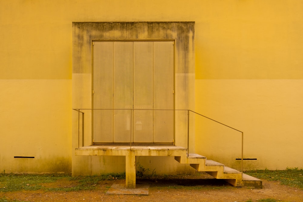 white concrete building with gray wooden door