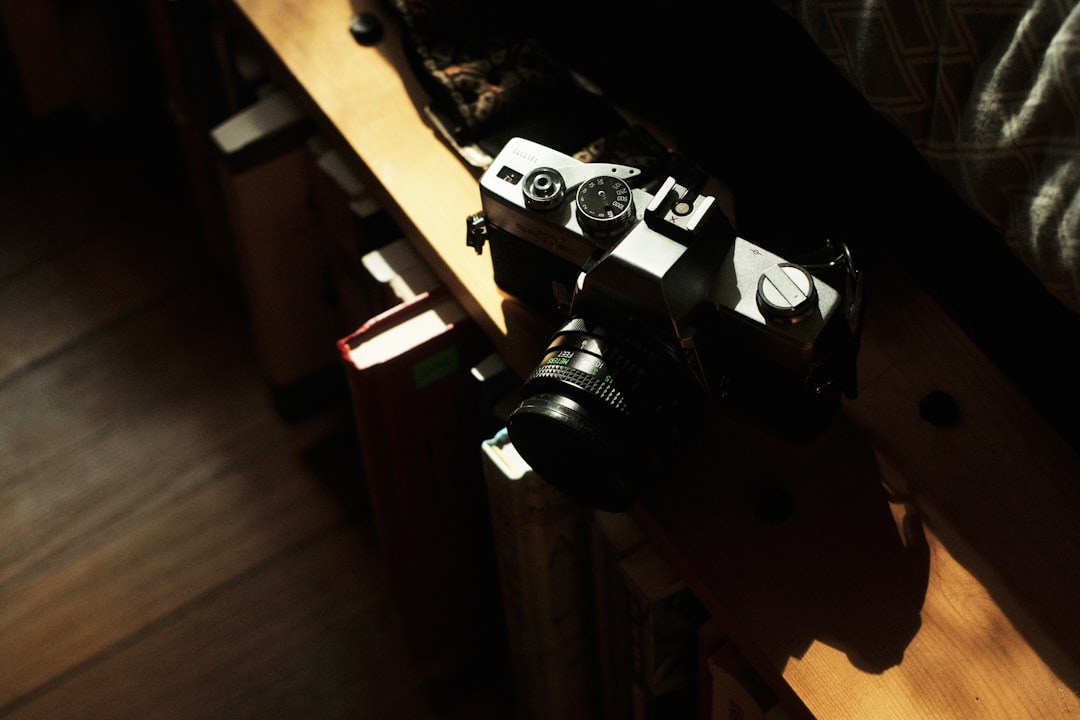 black and silver dslr camera on brown wooden table