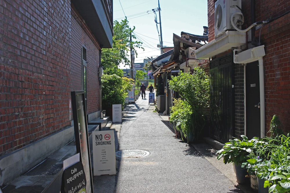 Plantes vertes à côté d’un bâtiment en briques brunes pendant la journée