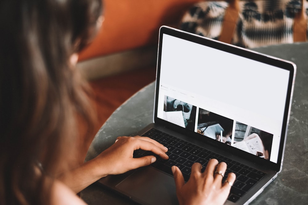 woman using macbook pro on table