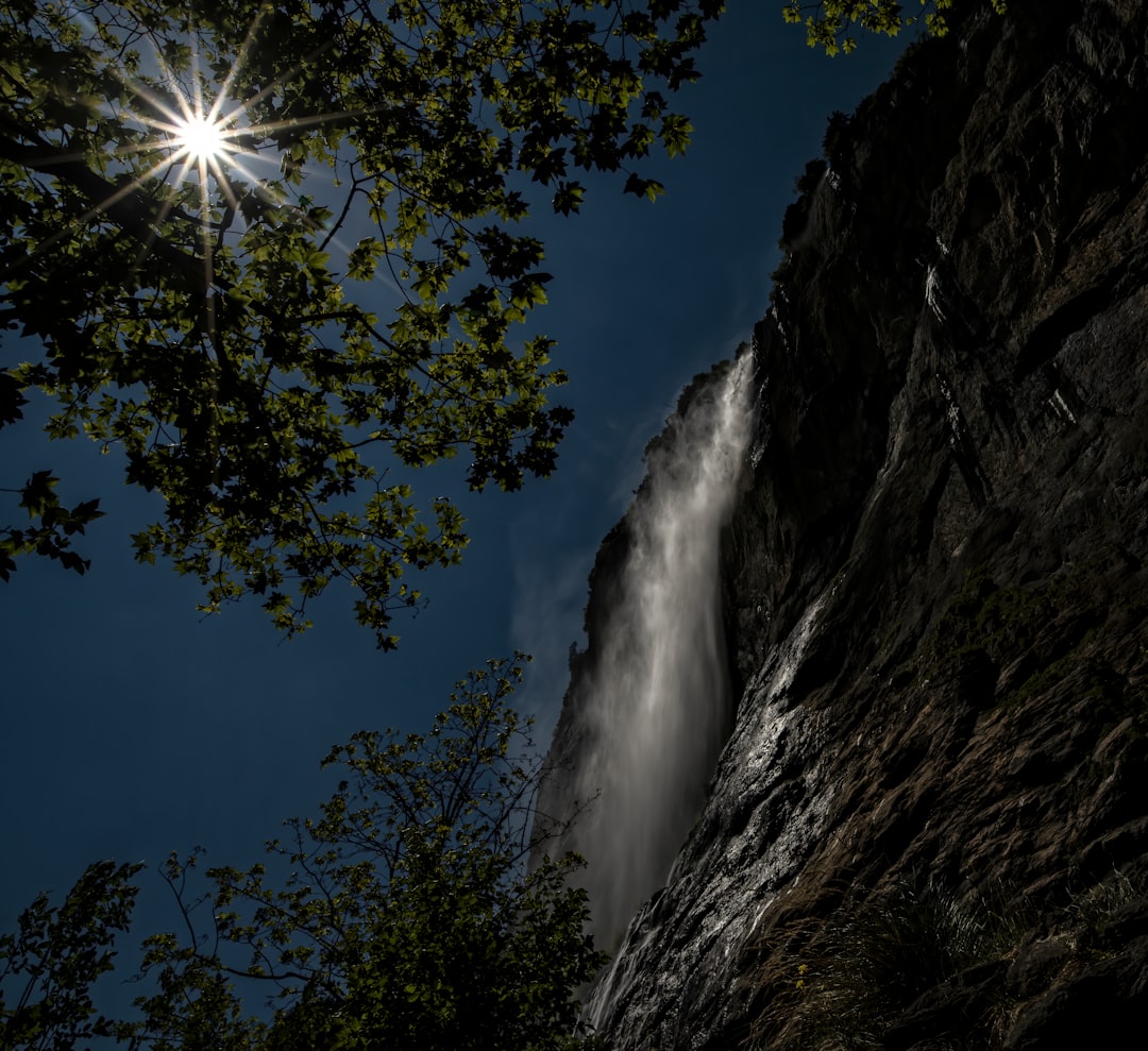 low angle photography of waterfalls under blue sky during daytime