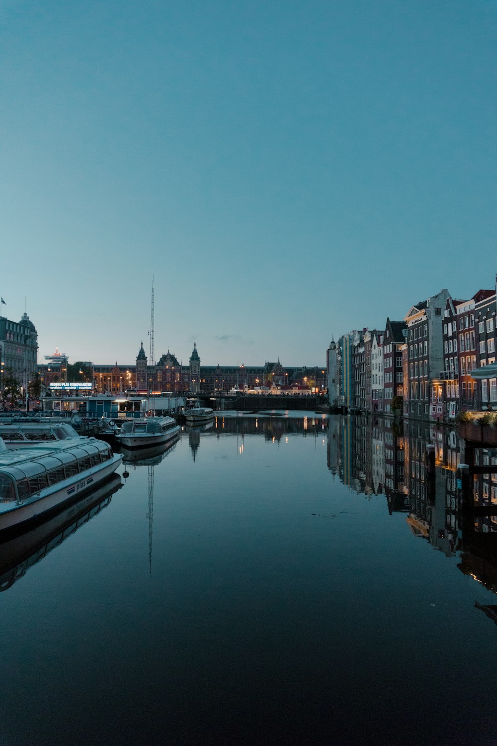 white and black boat on river near city buildings during daytime