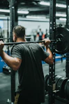 A person performing a squat with proper form in a bright gym setting.