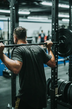 Athlete performing a deep squat with perfect form in a modern gym setting
