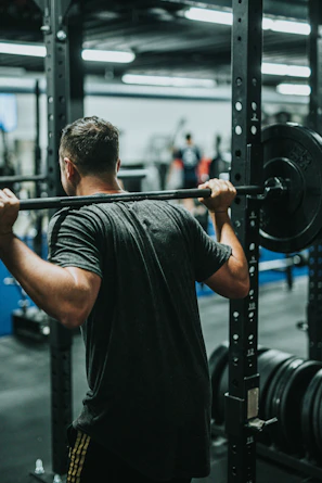 Client performing a controlled squat with focused posture under coach’s watchful eye.