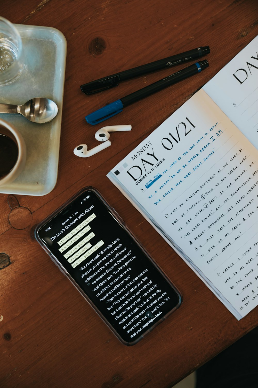 white printer paper beside black pen and white ceramic mug on brown wooden table