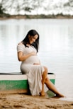 woman in white dress sitting on green bench