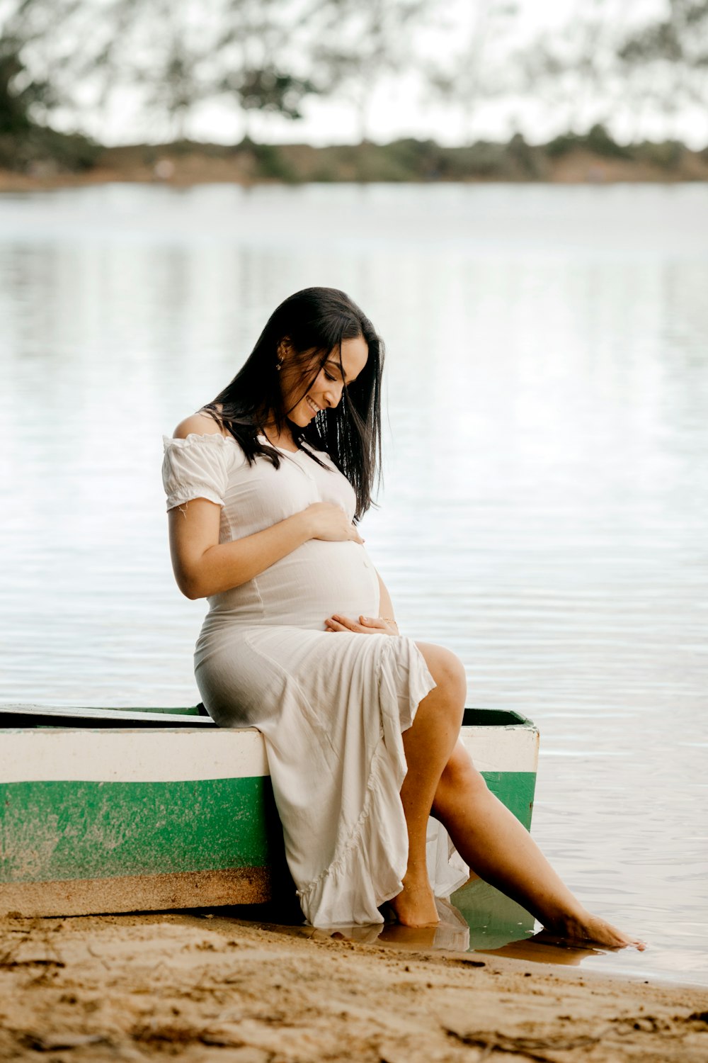 Femme en robe blanche assise sur un banc vert