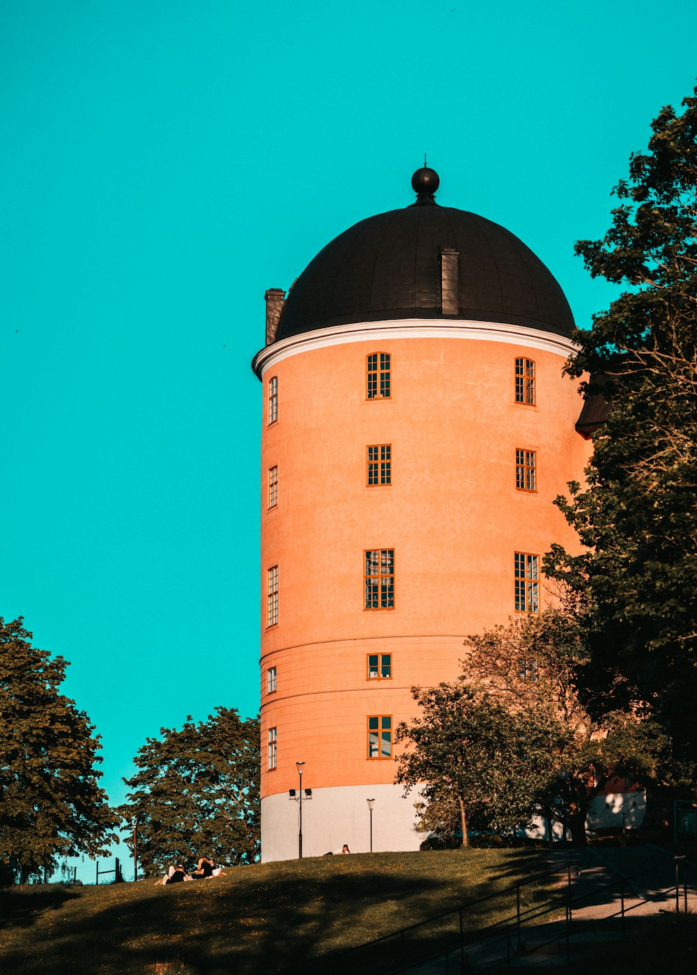 Braunes Betongebäude in der Nähe von grünen Bäumen tagsüber