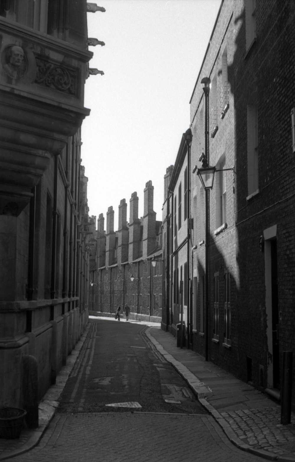 grayscale photo of empty street between buildings