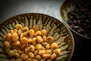 Close-up of premium dry fruits from Saryu Dry Fruits brand in a stylish bowl with dark green accents