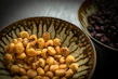 Close-up of roasted ginguba nuts spilling from a traditional woven basket.