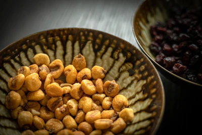 Close-up of colorful assorted nuts and dried fruits neatly arranged in small bowls.
