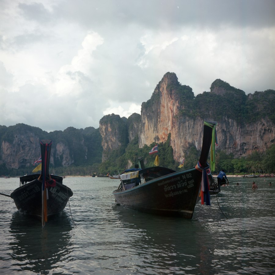Boat beside a limestone rock near Phra Nang Beach, Krabi
