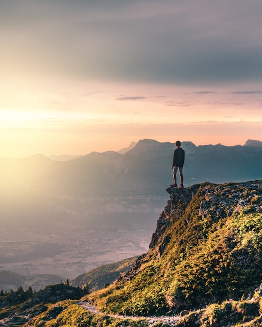 man standing on rock mountain during daytime in Rhône-Alpes France