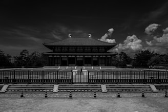 grayscale photo of building near trees