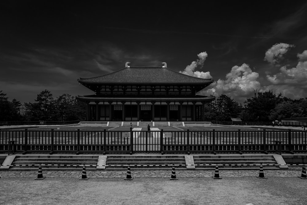 grayscale photo of building near trees