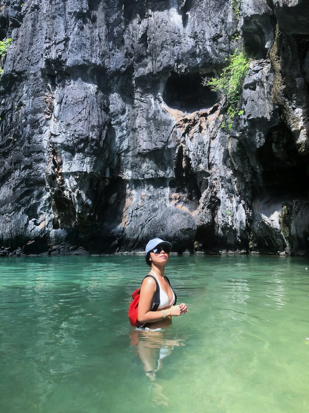 woman in black bikini on body of water during daytime