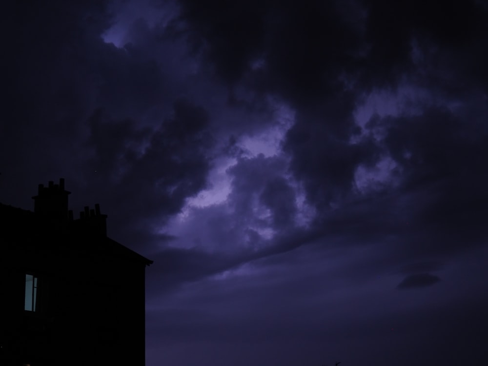 silhouette de bâtiment sous ciel nuageux