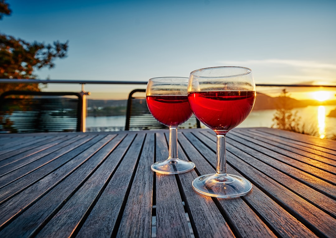 2 clear wine glasses on brown wooden table